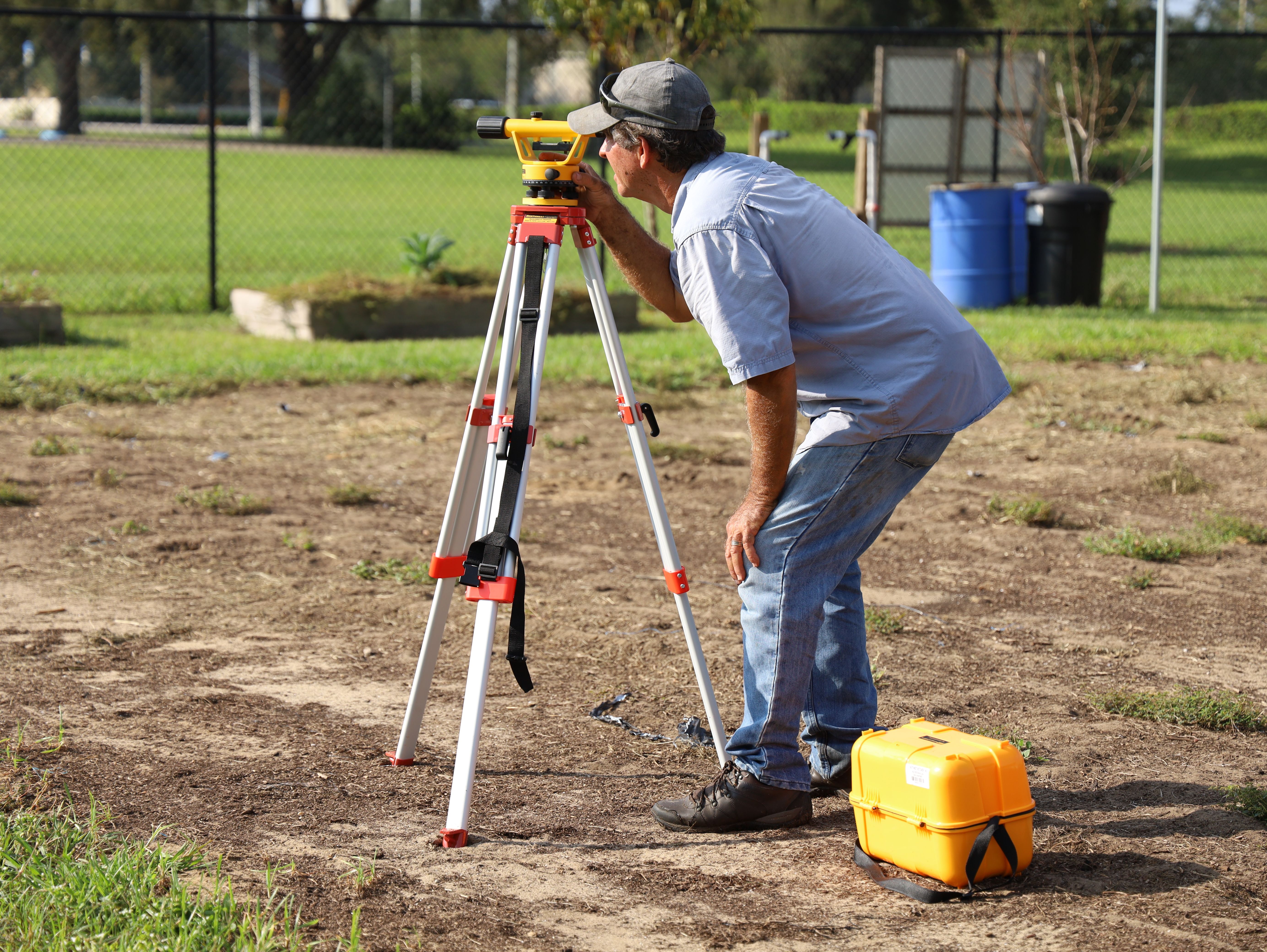A land surveyor using a total station in the field